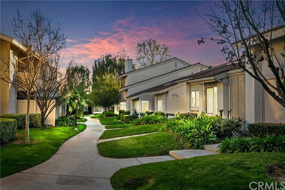 Front view of a residential building with multiple units and a pathway.