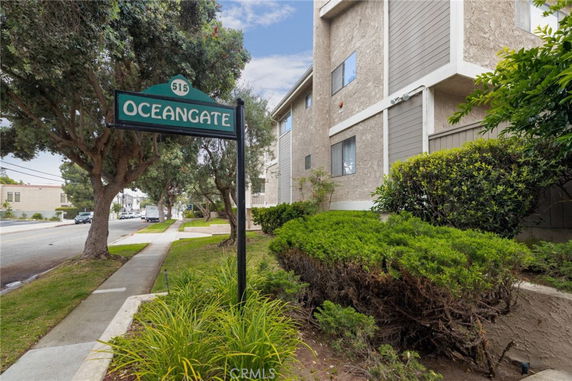 View of a multi-story building with a sign reading 'Oceangate' and lush greenery surrounding the pathway.