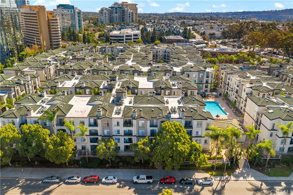 Aerial view of a large residential complex with multiple buildings and a central swimming pool.