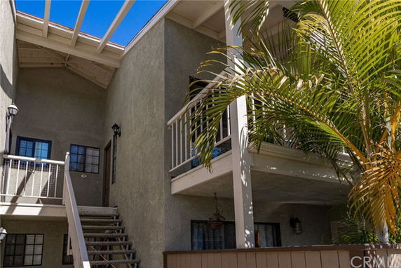 Corner view of a multi-level residential building with stairs and balcony.