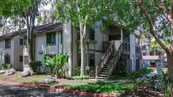 Front view of a two-story residential building with stairs leading to the second floor.