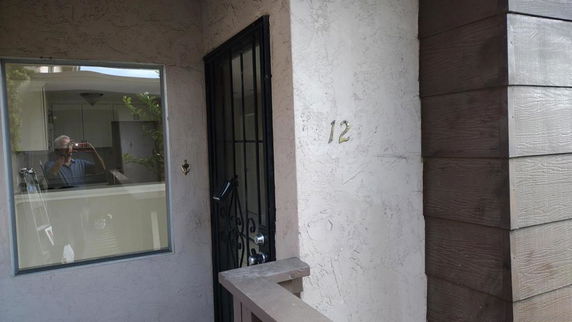 Front view of a house entrance with window and door, number 12 displayed.