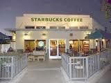 Front view of a Starbucks coffee shop with outdoor seating area.