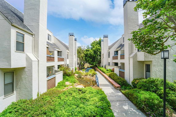 View of residential buildings with walkways and greenery.