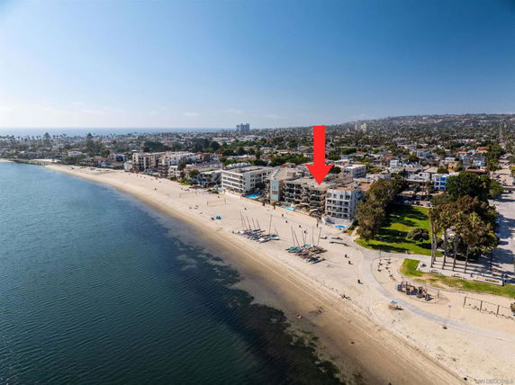 Aerial view of a beachfront area with buildings, sandy beach, and ocean.
