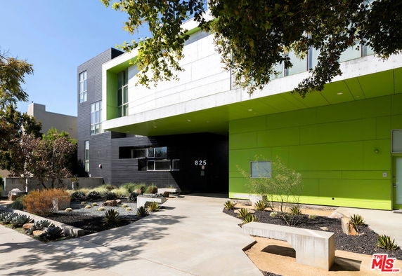 Front view of a modern building with green and gray exterior.