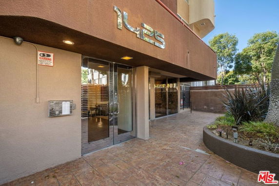 Front view of a building entrance with glass doors and a visible building number.