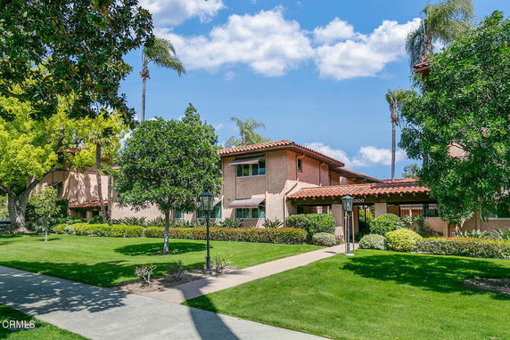 Front view of a two-story house with a red tiled roof and landscaped garden.