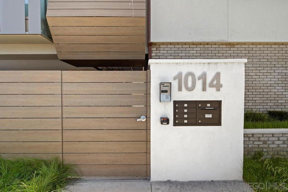 Front view of a building entrance with modern gate and wall-mounted mailboxes.