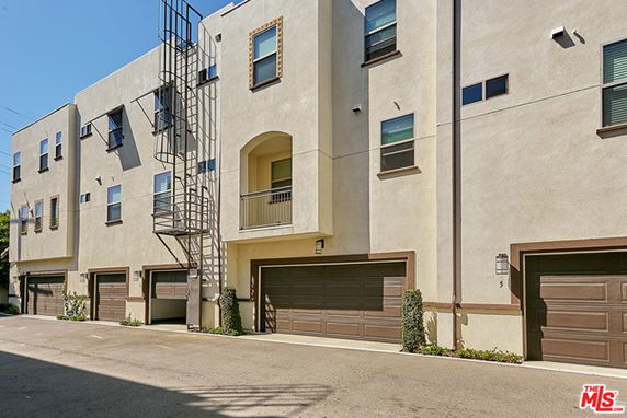 Front view of a modern multi-story building with garages.
