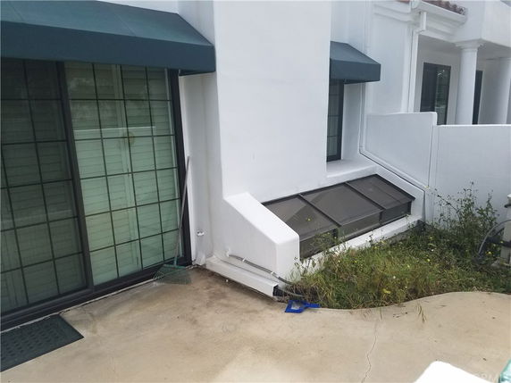Exterior view of a building with sliding glass doors and rectangular roof window.
