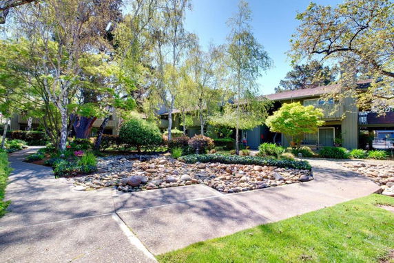 Front view of a two-story house with a landscaped garden and stone pathway.
