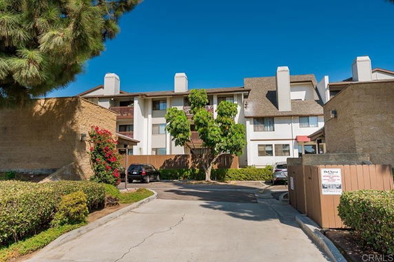 Front view of a multi-story residential building with multiple entrances and balconies.