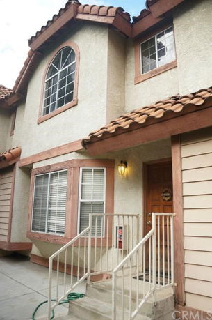 Front view of a house with a wooden door and arched windows.