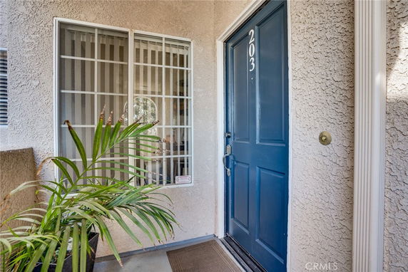 Front view of an entrance with a blue door and barred window.