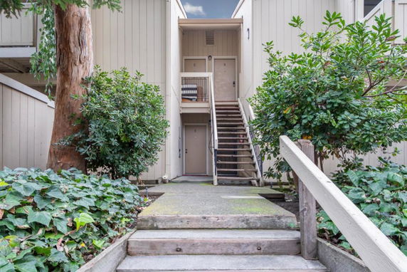 Front view of a building with stairs leading to upper level entrances.