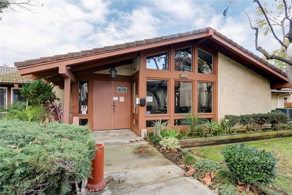 Front view of a house with large windows and a slanted roof.