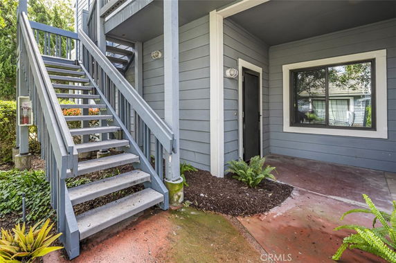 Front view of a house with an external staircase and entrance.