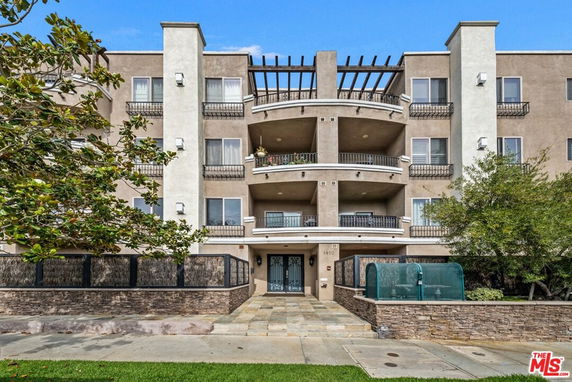 Front view of a multi-story apartment building with balconies.