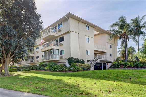 Front view of a multi-story apartment building with balconies and exterior staircases.
