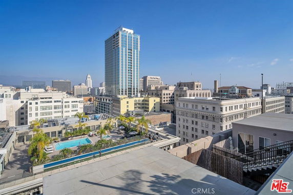 Panoramic view of cityscape from a rooftop with visible swimming pool.