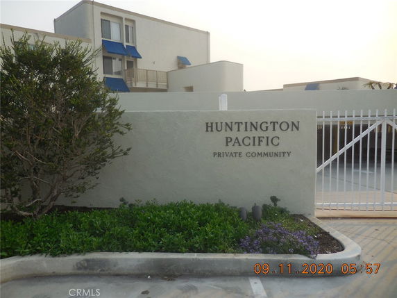 Front view of a building in a private community with blue awnings and a gated entrance.