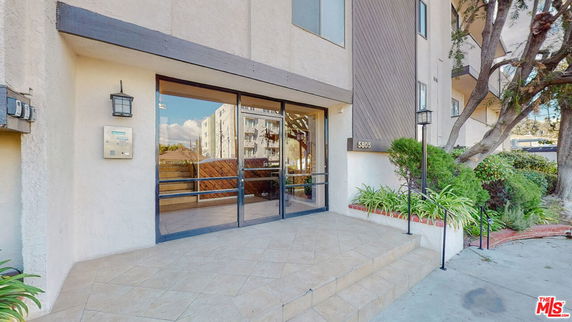Front view of a building entrance with glass doors and tiled steps.
