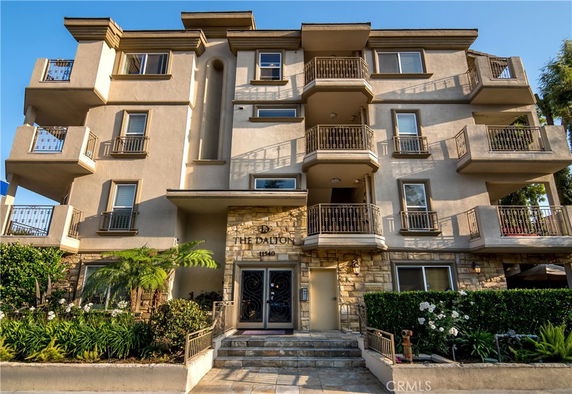 Front view of a multi-story residential building with balconies.