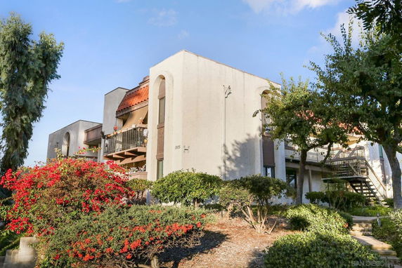 Front view of a multi-story building with balconies and external staircases.