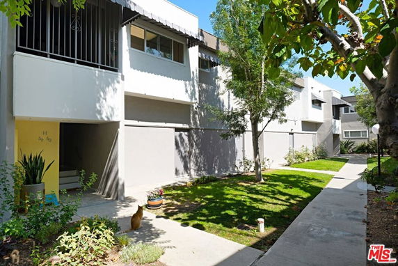 Front view of a residential building with multiple units and landscaped surroundings.
