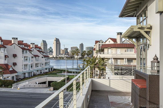 View from a balcony overlooking a waterfront with buildings and cityscape in the background.