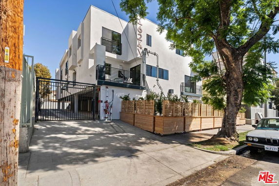 Front view of a modern multi-story building with gated entrance.