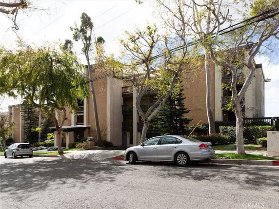 Front view of a multi-story apartment building with balconies.