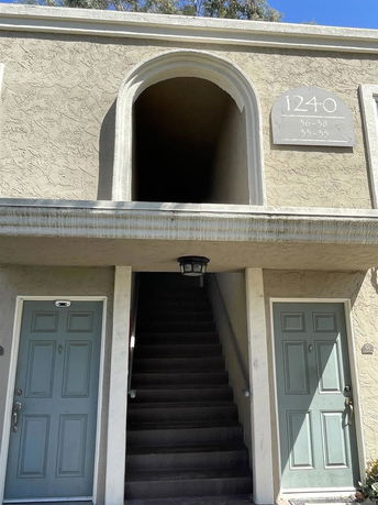 Front view of a two-story building with an arched entryway and two doors.