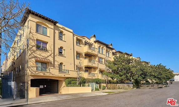 Front view of a multi-story building with balconies and arched windows.