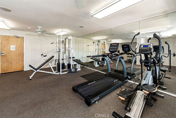 Indoor gym area with exercise equipment including treadmills and weights.