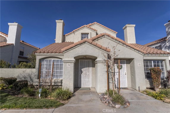 Front view of a two-story house with two entrances and a tiled roof.