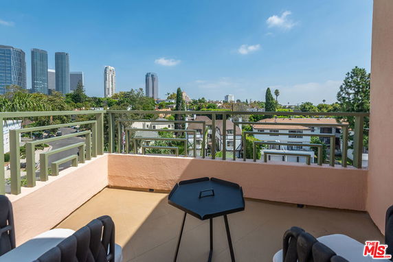 View from a balcony overlooking a cityscape with tall buildings in the distance.