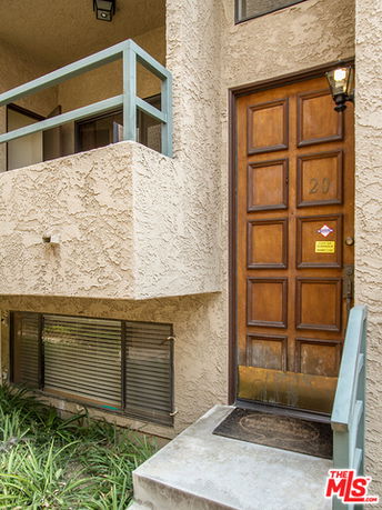 Front view of a building entrance with a wooden door and steps.