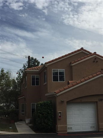 Front view of a two-story house with a double garage and tiled roof.