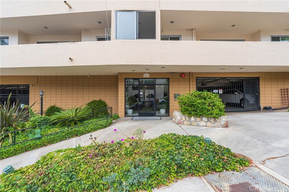 Front view of a building entrance with parking area and landscaping.