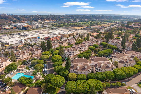 Wide aerial view of an urban area with multiple residential buildings and commercial complexes.