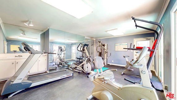 Room with various gym equipment including treadmills and exercise machines.