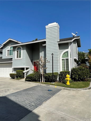 Front view of a two-story house with a single garage and a chimney.