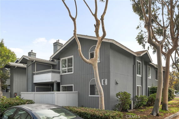 Front view of a two-story residential building with gray siding and white trim.