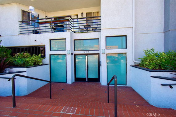 Front view of a building with glass doors and windows above brick steps.