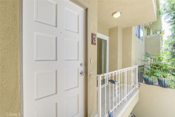 Entrance view of a house with a white door and balcony with plants.
