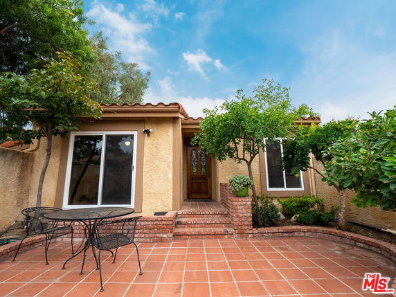Front view of a single-story house with a tiled patio and entrance.