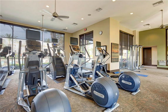 Indoor gym area with exercise equipment and large windows.