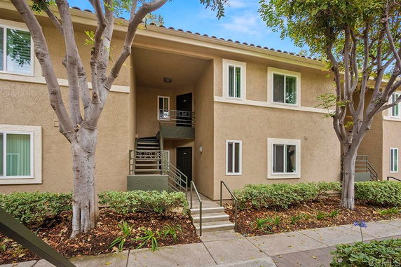 Front view of a two-story apartment building with stairs leading to upper units.